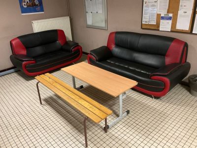 two black and red leather couches and a wooden table