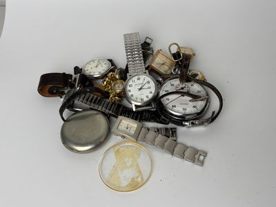 a pile of assorted watches and other watches on a table