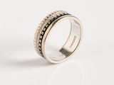 an image of a silver ring with black stones on a white surface