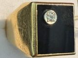 a gold and black ring with a diamond on it