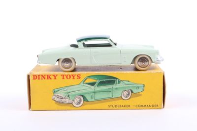 a green toy car sitting on top of a box