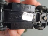 a person holding a black toy car in their hand