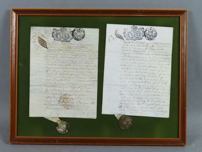 an old letter and a piece of paper on display in a wooden frame