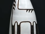 un vase blanc orné d'un motif noir et marron
