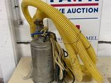 a yellow hose attached to a metal object on a table