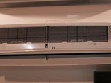 un climatiseur blanc accroché au mur à côté d'un téléviseur