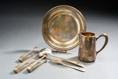 une assiette en argent et des couverts en argent posés sur une table