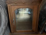 a small wooden cabinet with a mirror on top of it