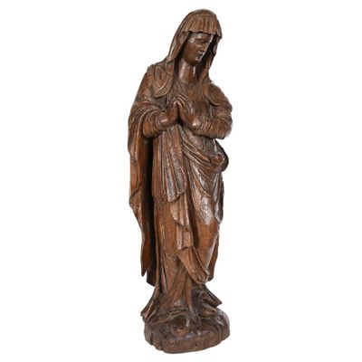 une statue en bois représentant une femme tenant un enfant