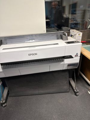 une grande imprimante posée sur un bureau dans une pièce