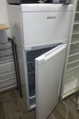 un réfrigérateur blanc dont la porte est ouverte, dans une cuisine