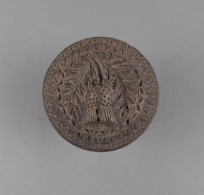 un vieux bouton en bronze orné d'un oiseau