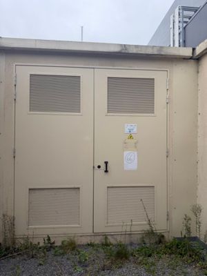 deux portes situées sur le côté d'un bâtiment sur lequel est accrochée une enseigne