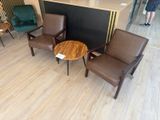 chairs and a table in a room with a bar in the background