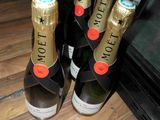 several bottles of champagne are lined up on a wooden table