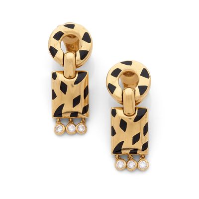 une paire de boucles d'oreilles noires et dorées ornées de pierres blanches