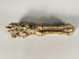 a gold colored object on a white surface