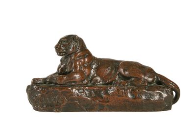 statue en bronze représentant un chien couché sur un rocher