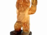 a small figurine of a baby on a wooden stand