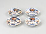 four small plates with designs on them are sitting on a table