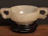 a white bowl on a black stand on a wooden table