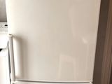 a white refrigerator sitting in a kitchen next to a stove