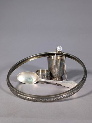 a silver plate with a spoon, spoon and spoon rest on it