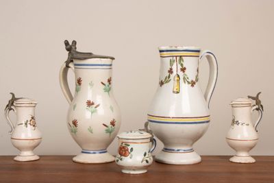 Ensemble de quatre pichets et un pot couvert en faïence du X…