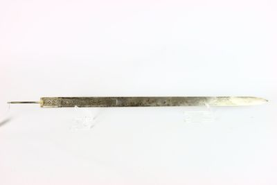 gros plan d'un petit objet métallique sur une surface blanche