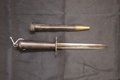 paire de couteaux anciens plaqués laiton posés sur un tissu noir