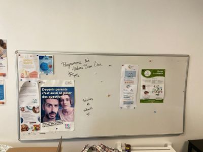 a white board with a bunch of papers on it