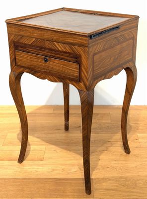 a small wooden table with a glass top on a hard wood floor