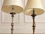 trois lampes posées sur un parquet, dans une pièce aux murs blancs