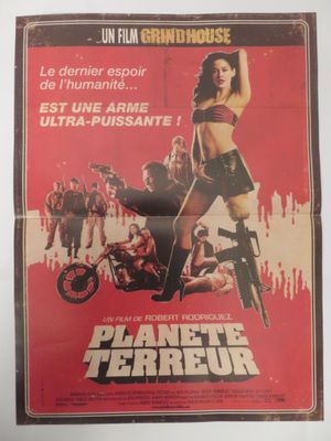 L'affiche du film « Planet Terror » est accrochée au mur.