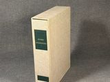 an old book sitting on top of a table next to a gray background