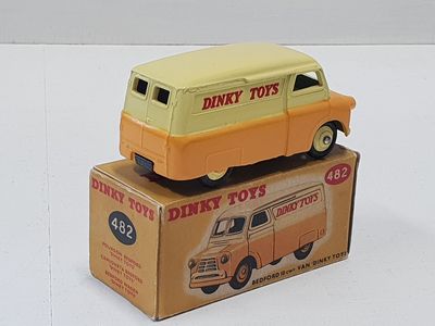un camion jouet jaune et orange posé sur une boîte