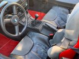 a red and black interior of a car with a steering wheel