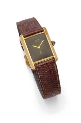 a close up of a watch on a white surface with a brown strap