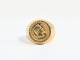 Gros plan sur une bague en or ornée d'une pièce de monnaie