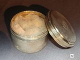 a silver tin with a cork in it on a table