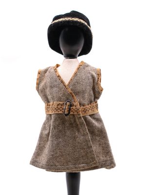 une poupée vêtue d'une robe marron et d'un chapeau noir, posée sur un mannequin