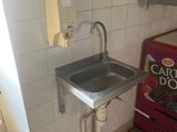 a sink and a soda machine in a small room