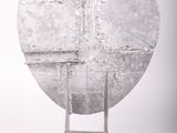 a metal sculpture of a circular object on a stand