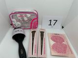 a bag of makeup brushes, a brush, and other items on a table