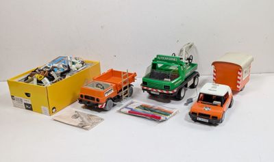 plusieurs camions jouets sont alignés sur une surface blanche