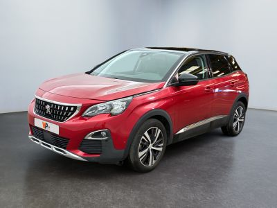 La voiture rouge est garée dans une pièce au sol noir.