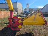 a red and yellow machine that is sitting in the grass