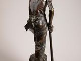 bronze statue of a man with a staff and a sword