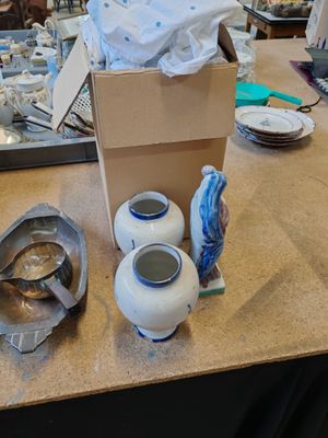 une table sur laquelle sont posés de nombreux vases et bols