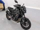 une moto noire garée dans une pièce avec une boîte